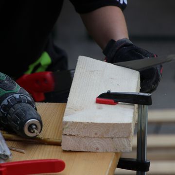 Eine Person sägt Holz.